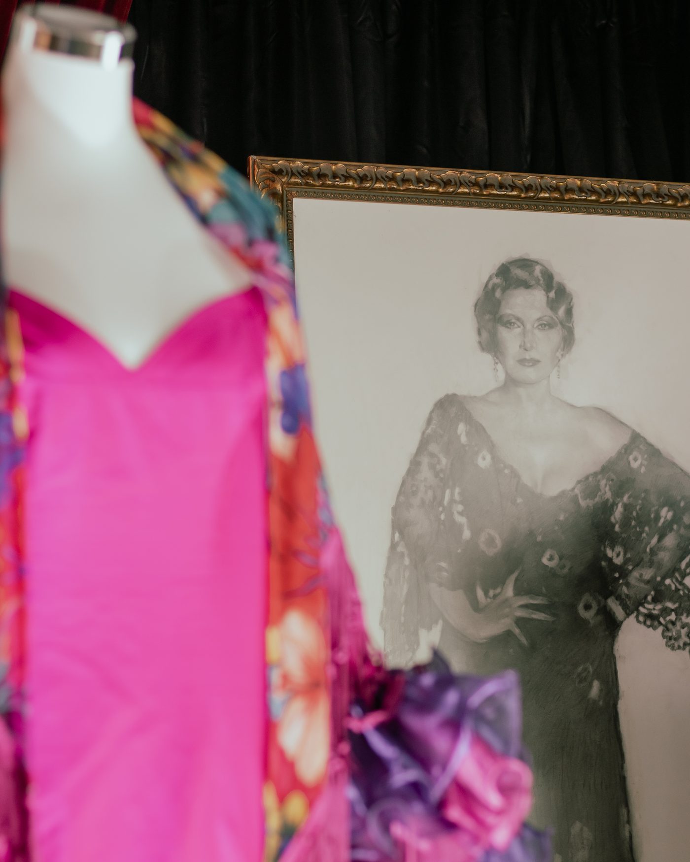 Rocío Jurado's pink gown beside a framed portrait of the singer