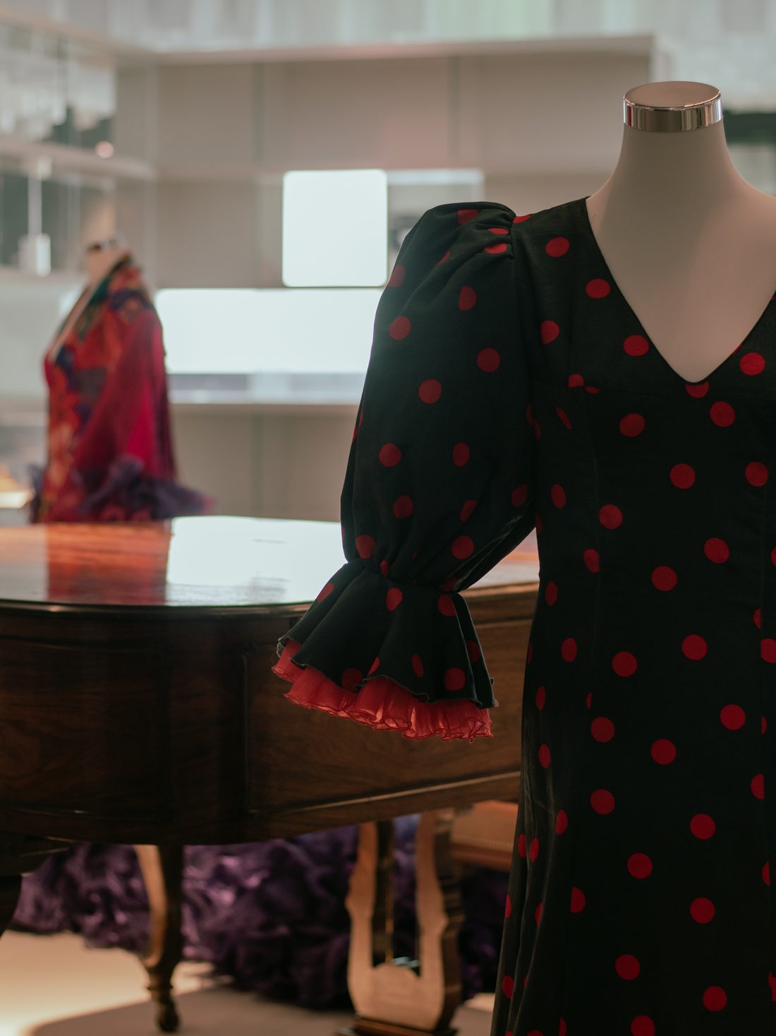 Rocío Jurado's black gown with red polka dots beside a grand piano