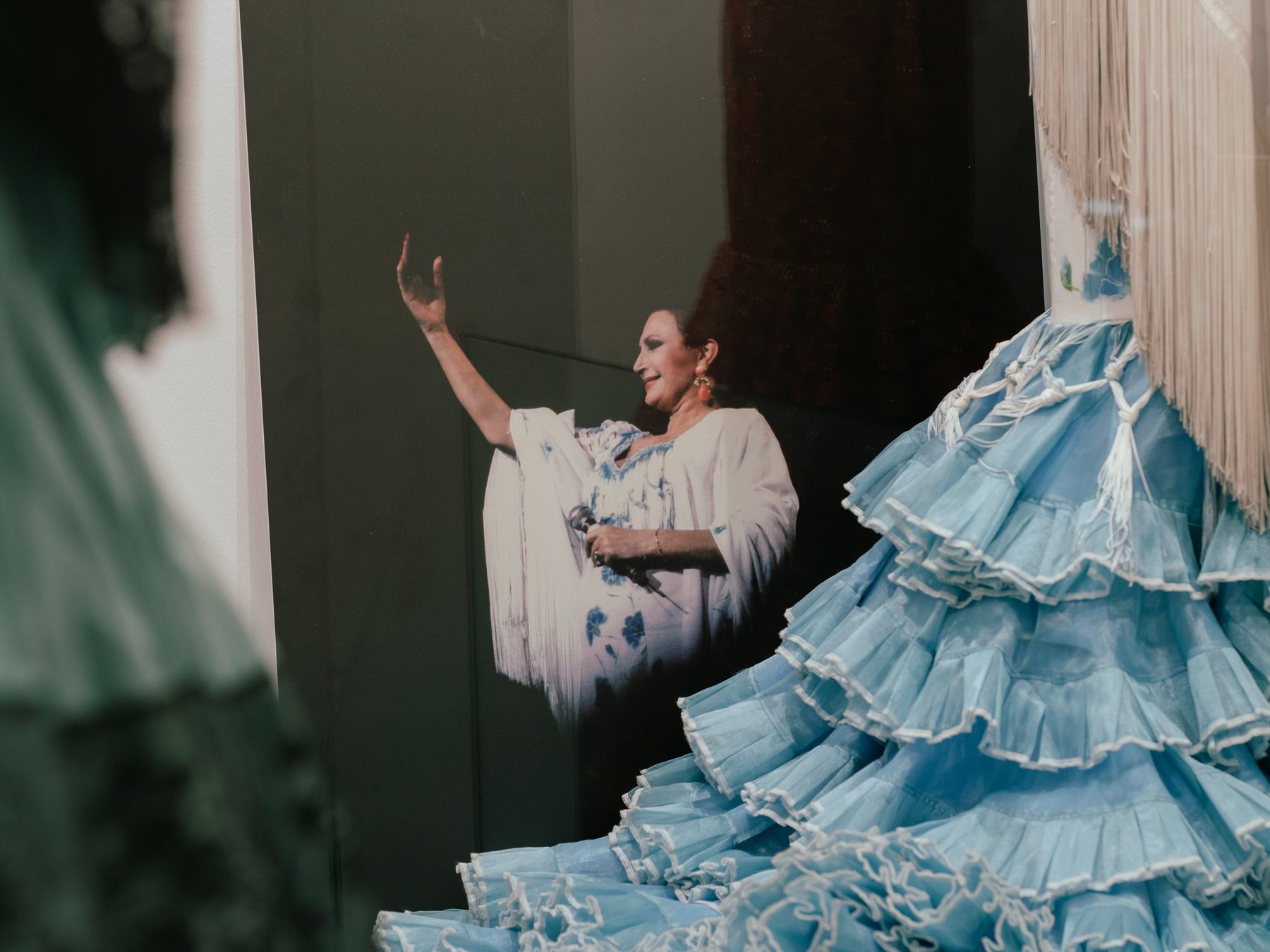 Blue flamenco gown and a photograph of Rocío Jurado greeting the audience on stage